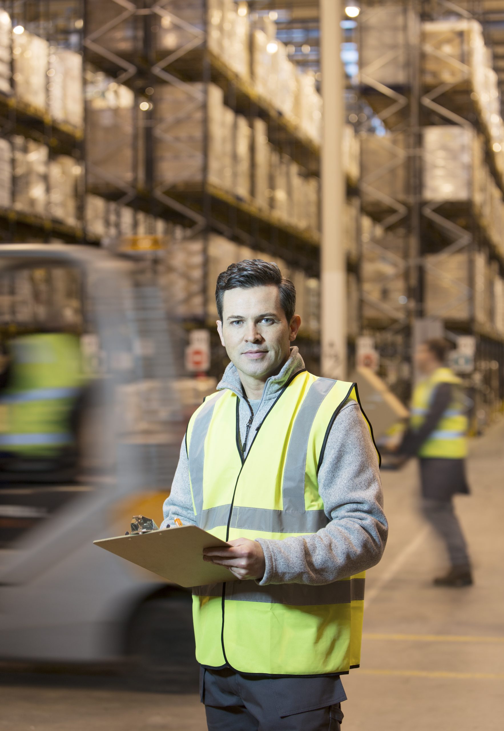Worker writing on clipboard in warehouse